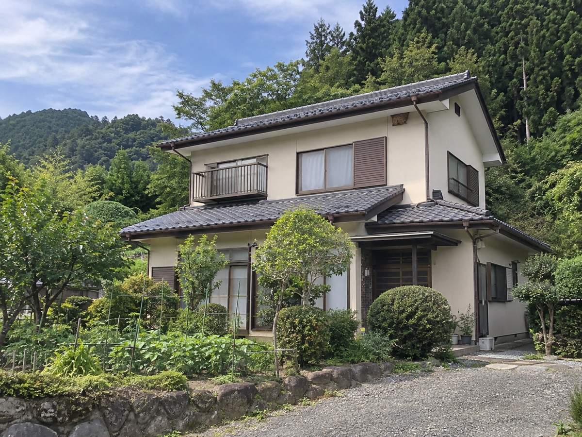 施工前・八王子市美山町の住宅外観と裏手に迫る杉林